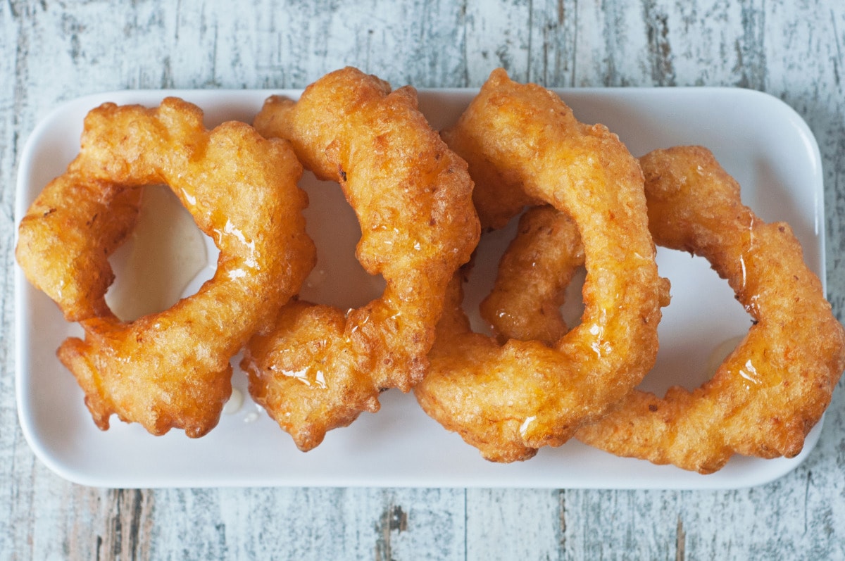 Picarones, a delicious donut-like ring, but without filling and with honey on top