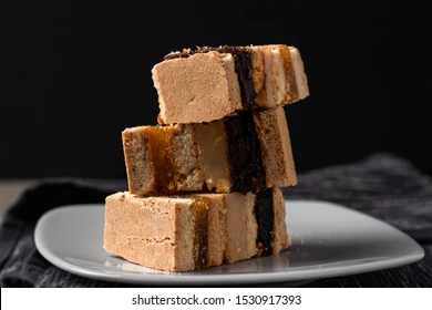 King Kong is a Peruvian dessert. The image shows layers of sponge cake filled with manjar blanco and dulce de leche.