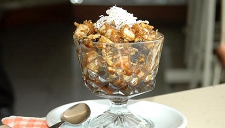 Ranfañote served in a glass glass, you can see the pieces of bread with nuts, coconut and cheese.